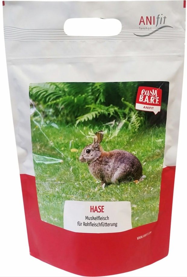 Beutel mit BARF für Hunde und Katzen, abgebildet ist ein Kaninchen, auf grünem Rasen fotografiert.