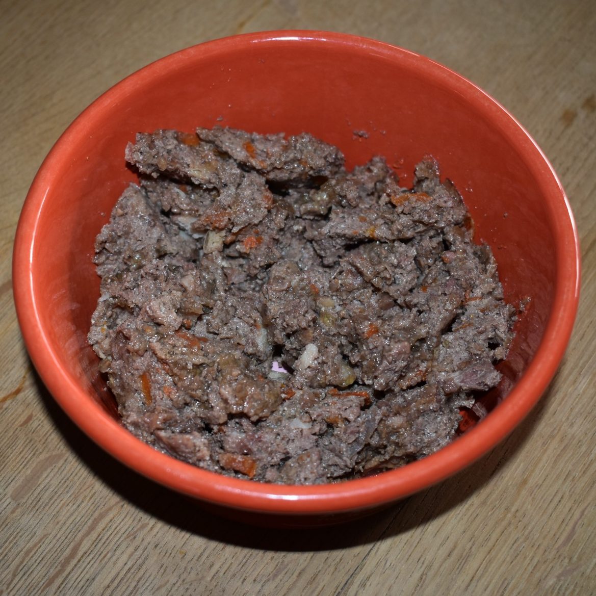 Fütterungsarten für Hunde und Katzen - Übersicht & Unterschiede Schalen mit verschiedenen Futterarten für Hunde und Katzen: Fleisch, Trockenfutter und Snacks.