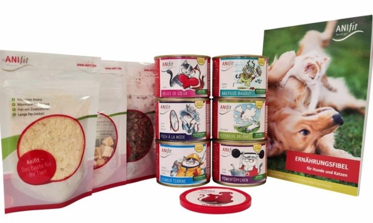 Inhalt des Katzen-Schnupperpaketes ansprechend arrangiert. Darunter verschiedene Dosen, Snacks und eine Ernährungsfibel.