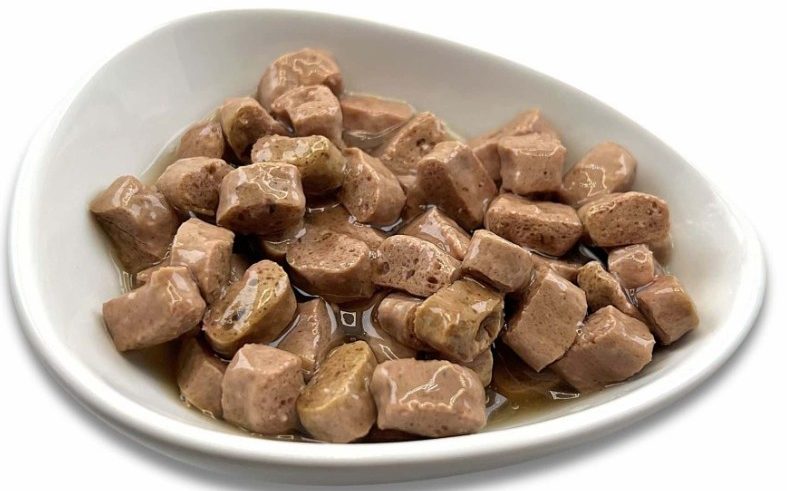 Feuchte, kleine Stücke von Katzenfutter in einer weißen Schüssel.