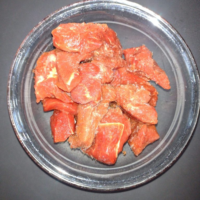 Rohes, gewürztes Fleisch in einer klaren Schüssel.