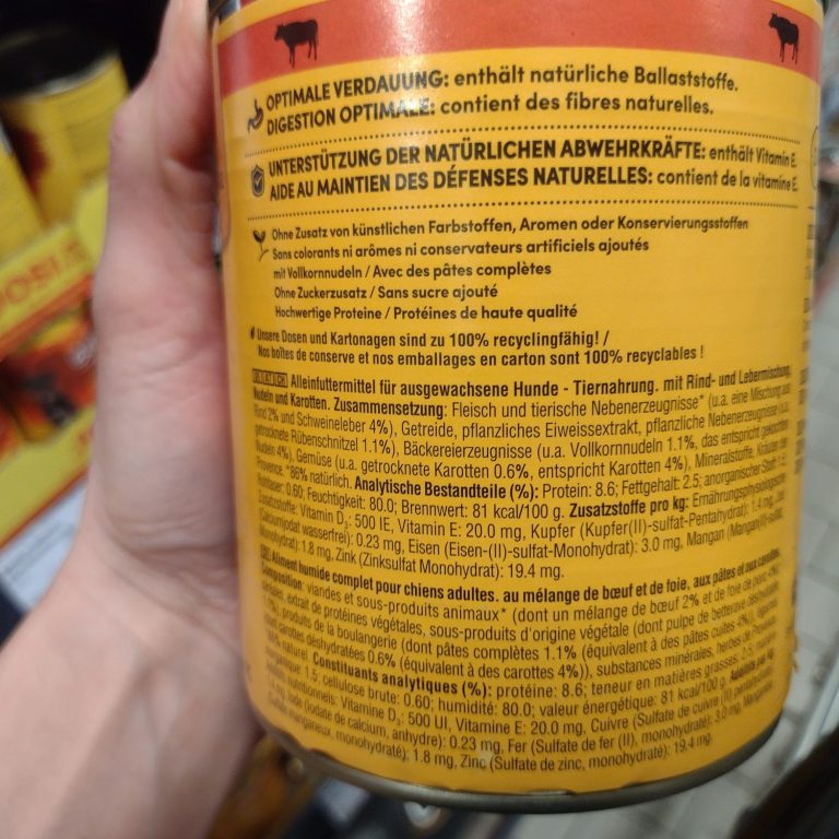 Hand, die eine Dose mit Informationen zu natürlichem Futter hält; Text auf Deutsch.