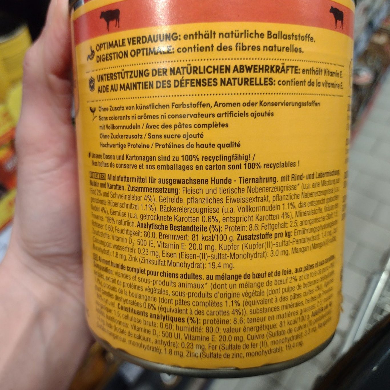 Deklaration von Katzen- und Hundefutter verstehen Hand hält eine Dose mit Inhaltsstoffen und Nährwertangaben auf der Etikette.